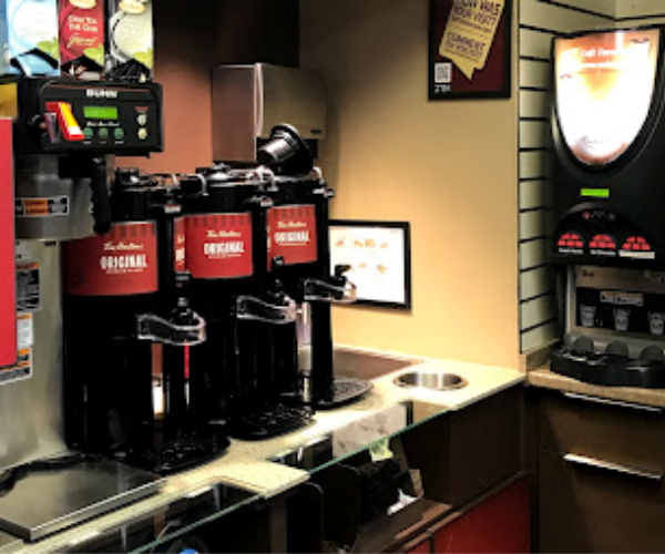 coffee station machine and a soda machine in a store.