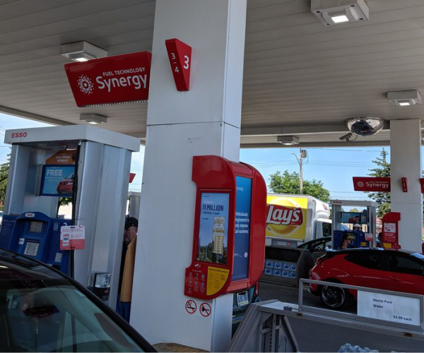 a red car is parked at a gas station.