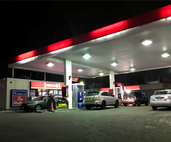 a gas station with cars parked in front of it.
