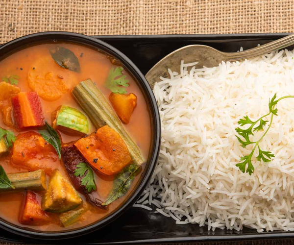 a plate of rice and a bowl of vegetable curry.