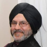 a man in a turban smiles at the camera.