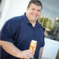 a man in a blue shirt holding a beer.