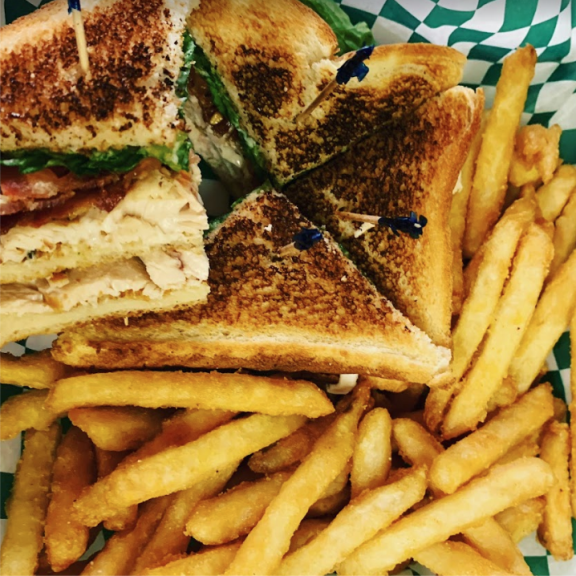 a club sandwich and french fries on a plate.