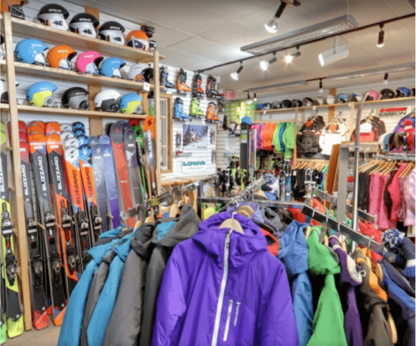 a rack of skis and snowboards in a store.