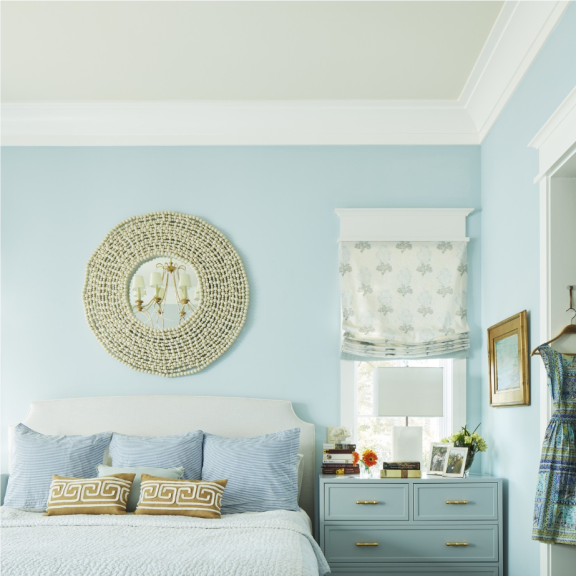 a bedroom with blue walls and a white bed.