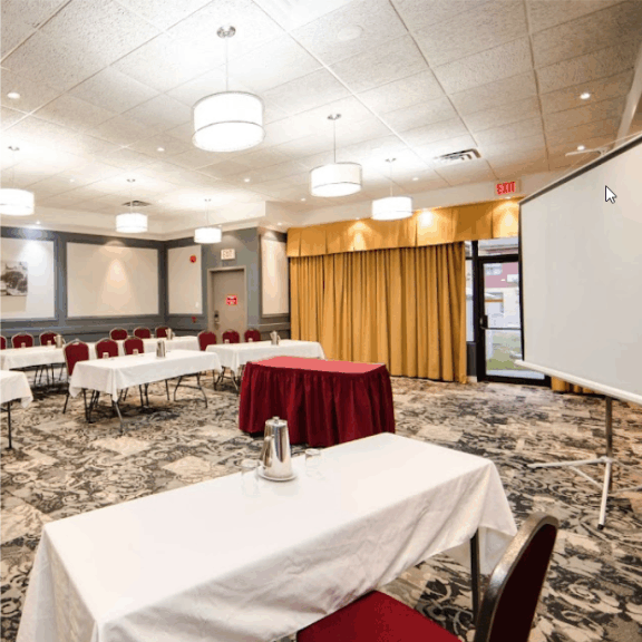 a conference room with a projector screen and tables.