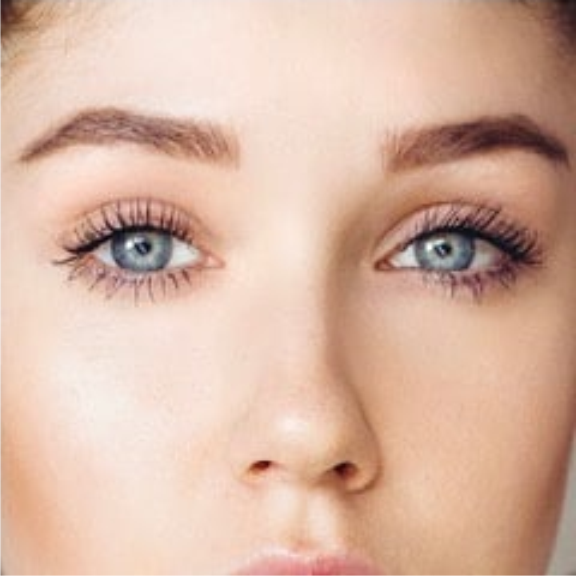 a close up of a woman with blue eyes and new eyelashes.