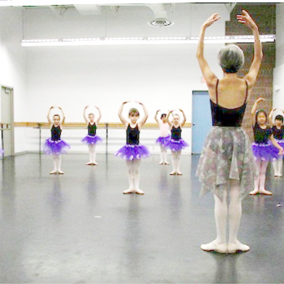 a group of young ballerinas in a dance studio.