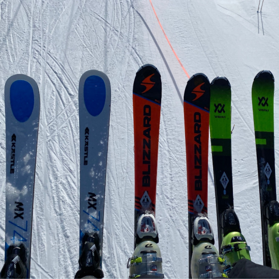a row of skis sitting on top of a snow covered slope.