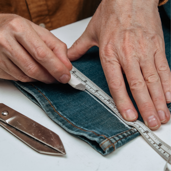 seamstress marking jeans to be hemmed