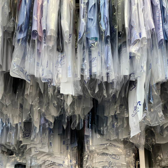 dry cleaned clothes hanging in racks