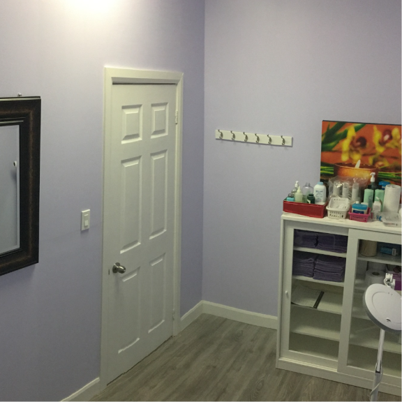 a private treatment room with purple walls and a white door.
