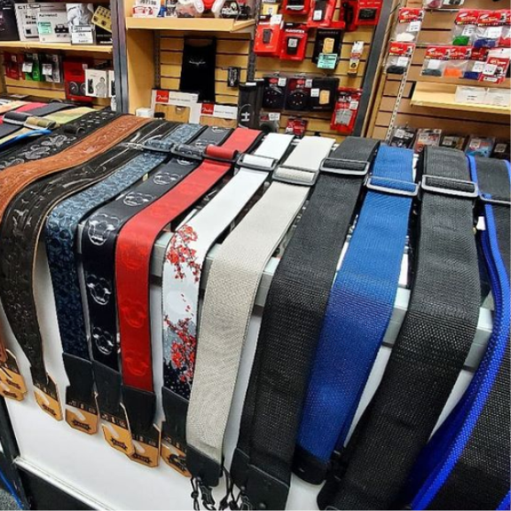 a store display with a variety of guitar straps on display.