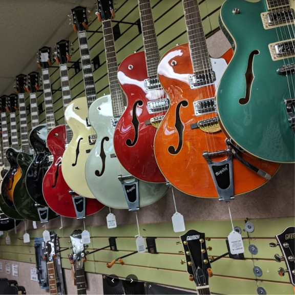 a group of guitars hanging on a wall.