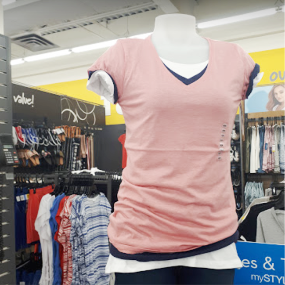 a women's clothing store with a display of shirts.