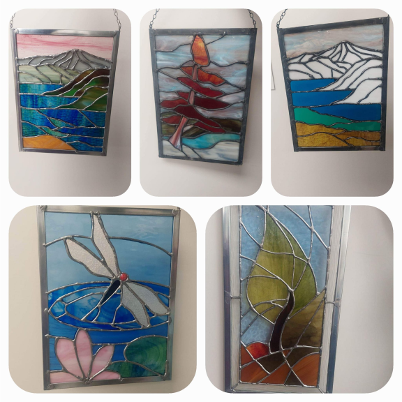 five different stained glass panels hanging on a wall.