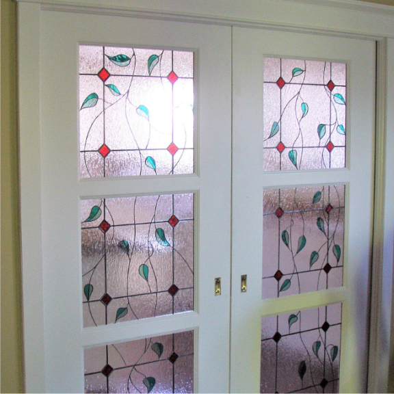 a pair of glass doors with a stained glass design on them.