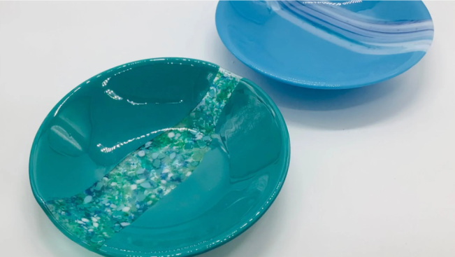 a blue bowl and a blue plate on a white table.