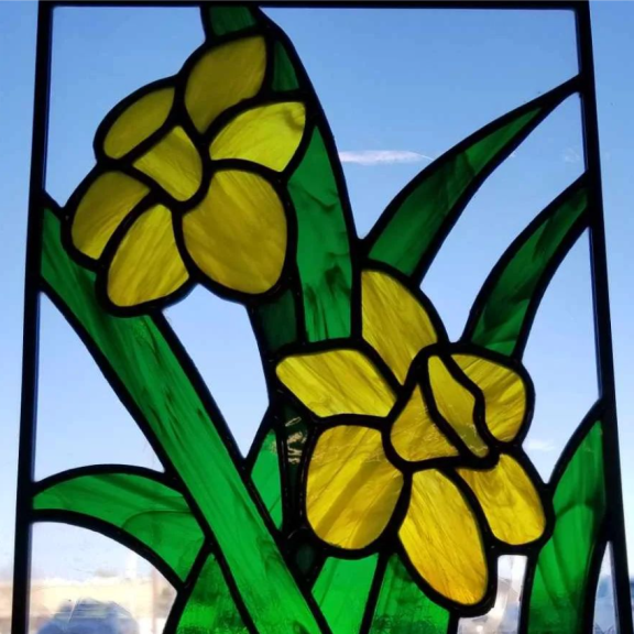 a close up of a stained glass window with flowers.