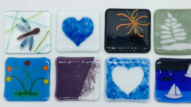 a set of nine glass coasters with different designs.
