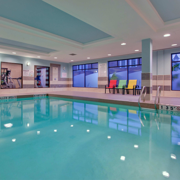 a large indoor swimming pool with chairs around it.