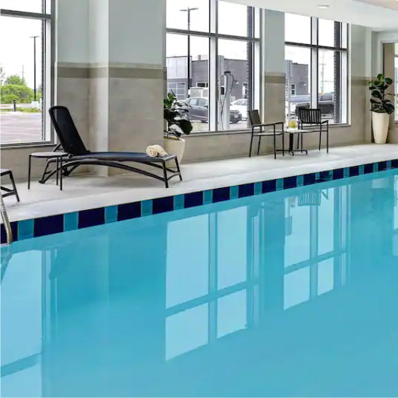 a large indoor swimming pool with chairs and tables.