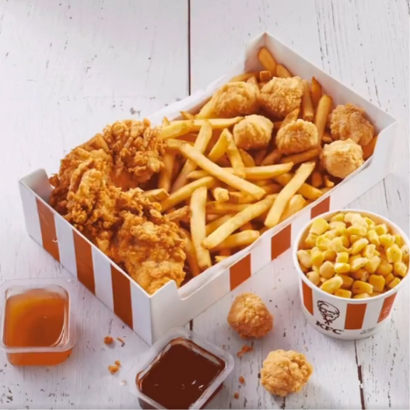 a box of chicken nuggets, french fries, and dipping sauce.