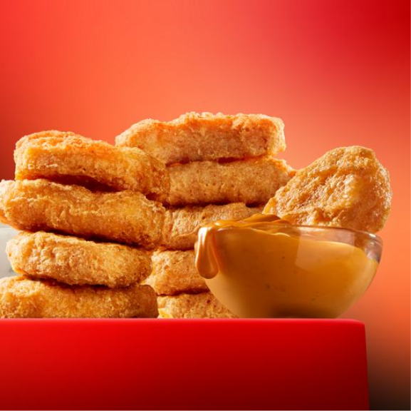 a stack of chicken mc nuggests with a bowl of dipping sauce.