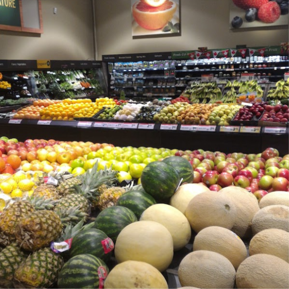 a display in a grocery store filled with lots of fruits.