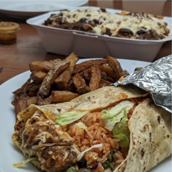 a plate of food with a burrito and some fries.