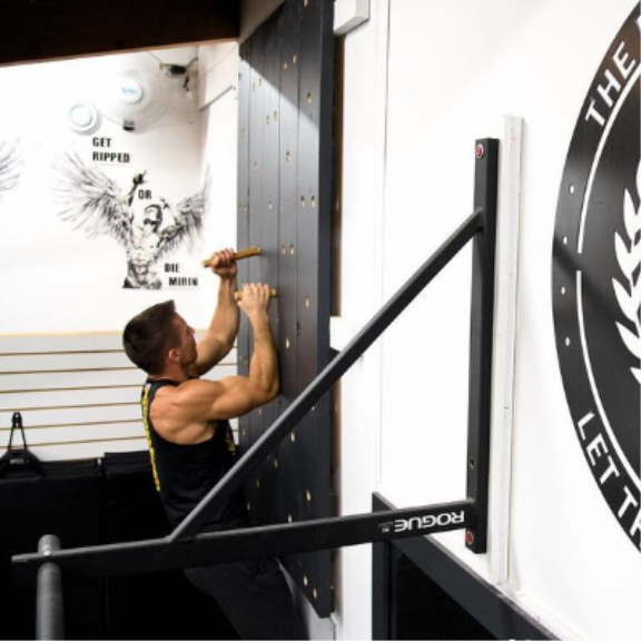 a man wall climbing in a gym.