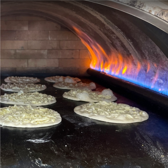 a bunch of lebanese pies cooking in an oven.