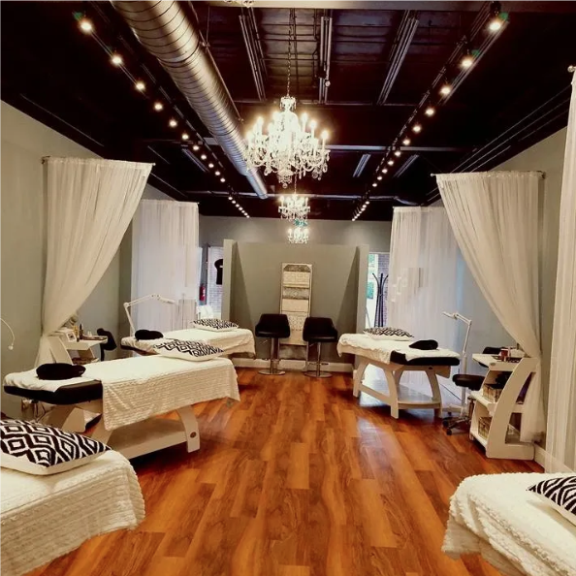 a room with several treatment beds and a chandelier.