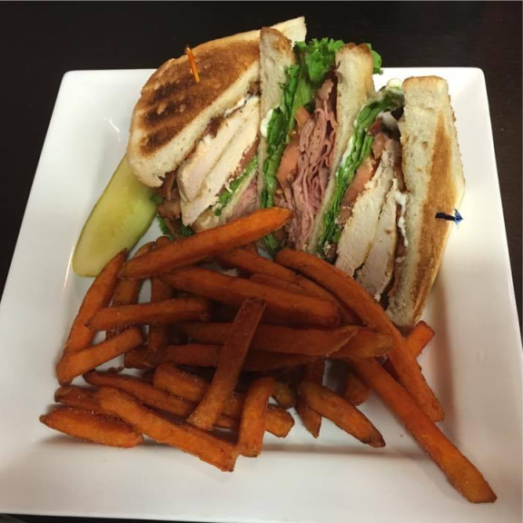 a white plate topped with a club sandwich and fries.