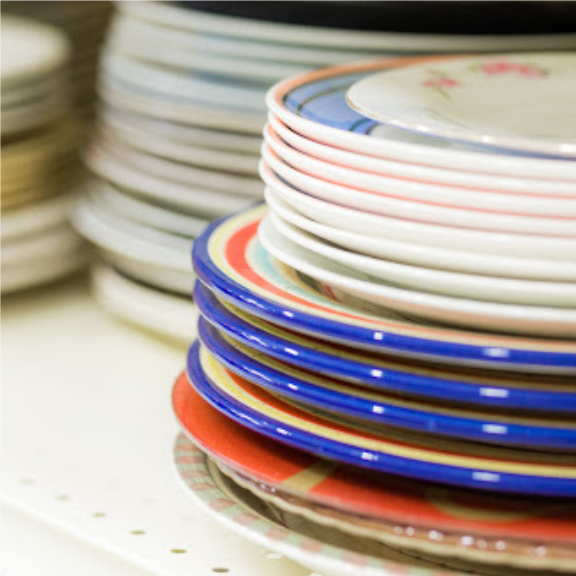 a stack of plates sitting on top of a shelf.