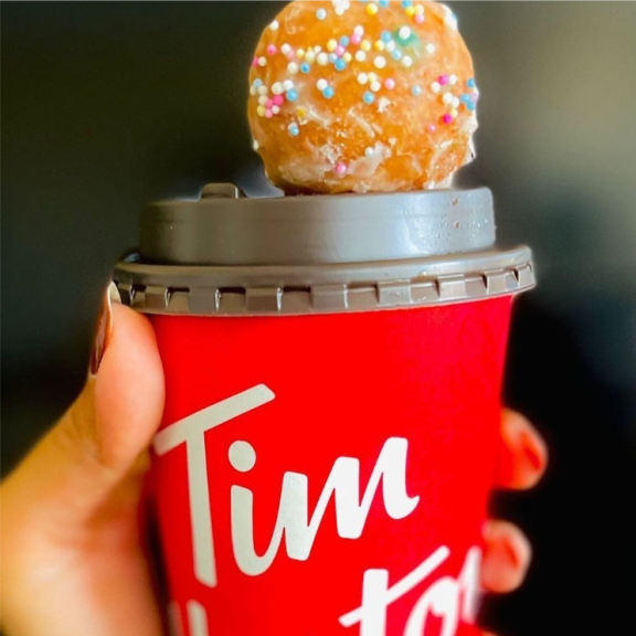 a donut sitting on top of a red cup.