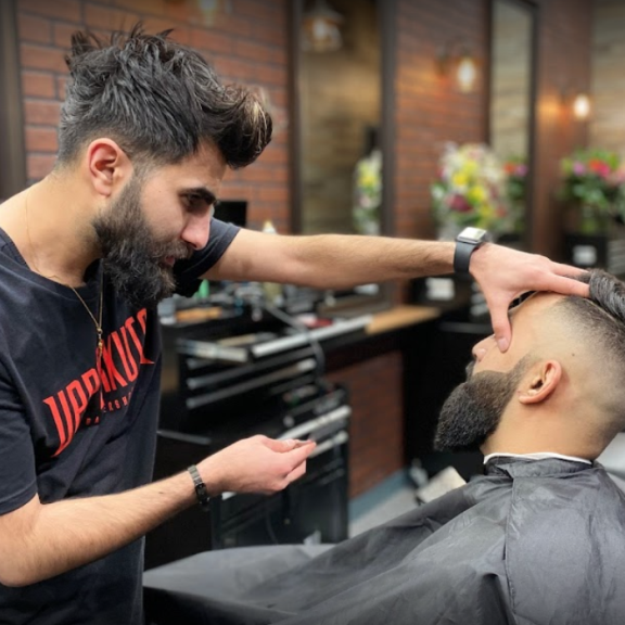 a man getting his hair cut by a barber.