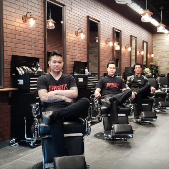 a group of men sitting in a barber shop.
