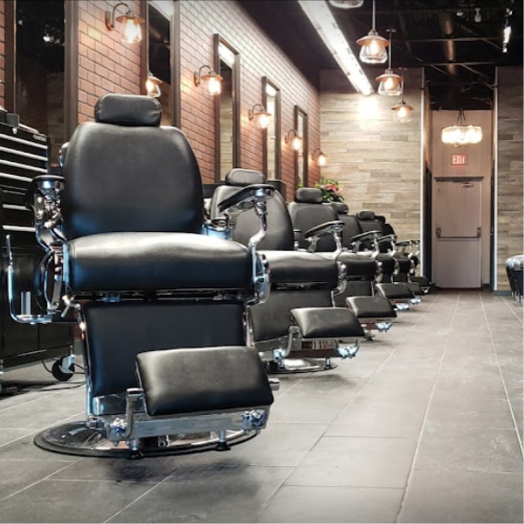 a row of black barber chairs sitting in a room.