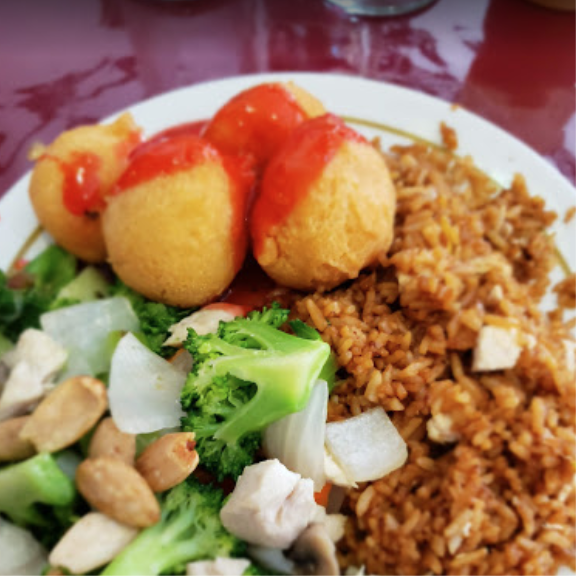 a white plate topped with rice, broccoli and chicken balls.