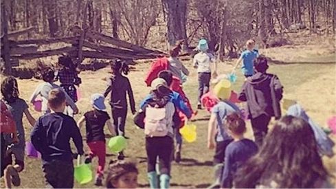 kids running down a forest path at the beginning of an easter egg hunt