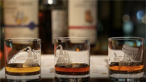three whisky glasses with a splash of whisky in each.