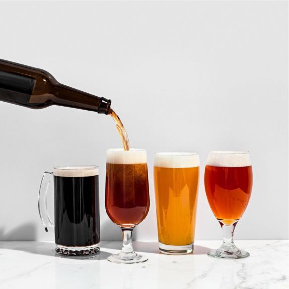 row of different colors of beer being poured