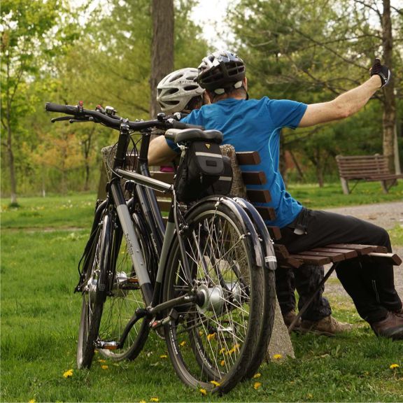 a man sitting on a bench next to a bike.