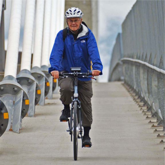 a man riding a bike across a bridge.