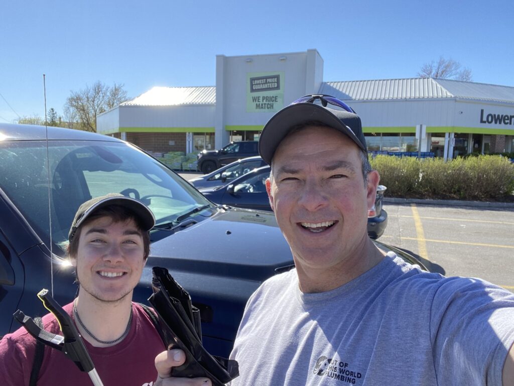 a man and a woman taking a selfie in front of a car dealership.