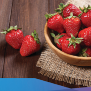 a bowl full of strawberries on a wooden table.