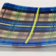 a blue and yellow plaid glass plate on a white surface.