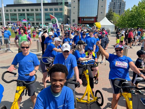 A group of people in blue shirts on bicycles.