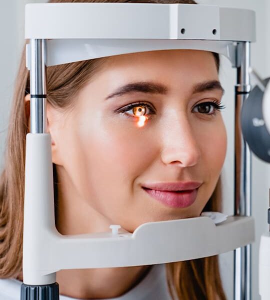 A woman is using an eye exam machine.